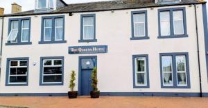 a white building with blue windows and a blue door at The Queens Hotel in Cardenden