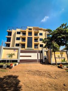 a large white building with trees in front of it at Snow View Residences in Msaranga