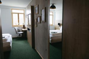 a hotel room with two beds and a desk with a chair at Grünbauer - Der Landgasthof in Reuth bei Erbendorf