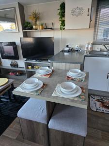 a kitchen with a table with plates on it at Luxury static caravan in Beattock
