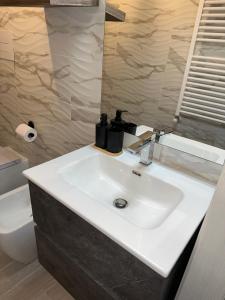 a bathroom with a white sink and a toilet at Residenza Ohana in Isernia