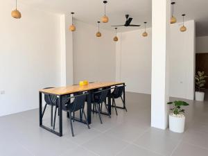 a dining room table with black chairs in a white room at Hiraya Guesthouse in Ukulhas