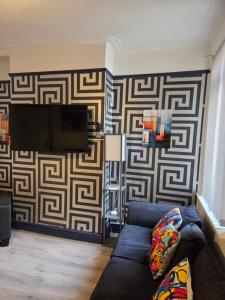 a living room with a couch and a tv on a wall at Ince House in Liverpool +35 photos