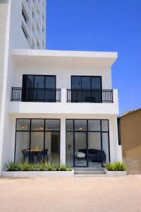 a white house with black windows and a table at Hiraya Guesthouse in Ukulhas