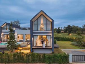 a person taking a picture of a house at I-DIN POOL VILLA khaoyai in Ban Nong Song Hong