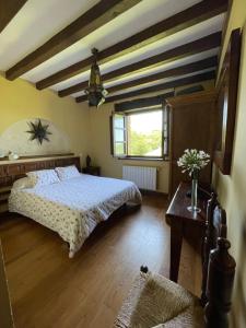 a bedroom with a bed and a table and a window at Posada Rural Valoria in Valoria +14 photos