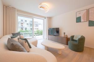 a living room with a couch and a tv at The Captainhouse in Nieuwpoort