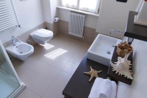 a bathroom with a toilet and a sink with a starfish on a counter at Villa Fiore in Novilara +9 photos