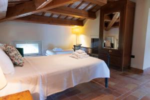 a bedroom with a large white bed and a mirror at Villa Fiore in Novilara