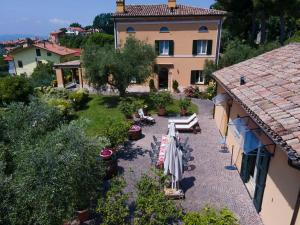 a garden with umbrellas and chairs in front of a building at Villa Fiore in Novilara