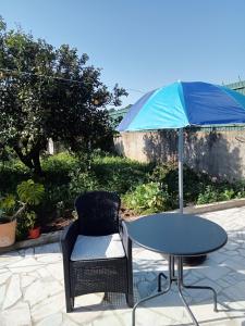 a table and a chair and an umbrella at Estúdio ensolarado in Fernao Ferro
