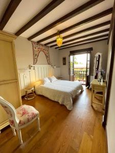 a bedroom with a large bed and a chair at Posada Rural Valoria in Valoria