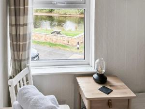 a room with a window with a table and a chair at Cygnet Cottage in Warkworth