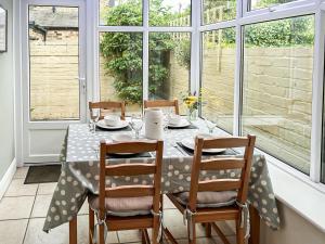 a dining room with a table and four chairs at Cygnet Cottage in Warkworth