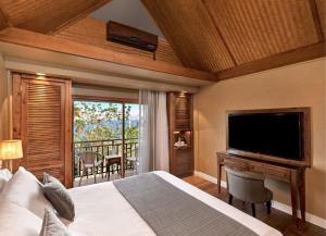 a bedroom with a bed and a flat screen tv at Orchid Eilat Hotel in Eilat
