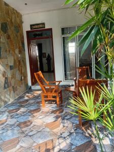a patio with two chairs and a stone floor at S And K Holiday Stay in Beruwala +2 photos