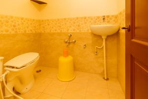 a bathroom with a toilet and a sink at Mysore Couple Friendly at 999 in Mysore