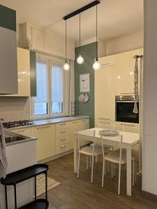 a kitchen with a white table and chairs and a table at Casa Angiolina in Chiavari