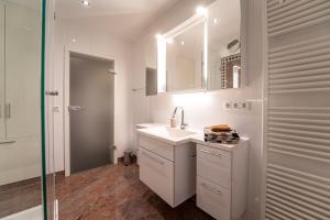 a white bathroom with a sink and a mirror at FeWo-Tannenriede in Braunschweig +20 photos