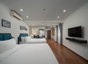 a bedroom with a large bed and a flat screen tv at Ritana Boutique Hotel & Spa in Hanoi