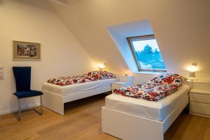 a attic room with two beds and a window at FeWo-Tannenriede in Braunschweig