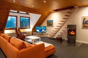 a living room with a couch and a staircase at FeWo-Tannenriede in Braunschweig