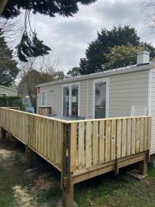 a mobile home with a wooden deck at l'impasse de la tranquillité in Pont-Aven