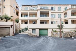 an apartment building with two garage doors and a driveway at Féeries Provençales YourHostHelper in Grimaud