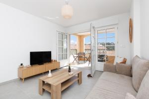 a living room with a couch and a tv at Féeries Provençales YourHostHelper in Grimaud