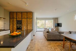 a kitchen and living room with a couch and a table at Bloemendaal Hotel Collection Apartments in Bloemendaal +21 photos