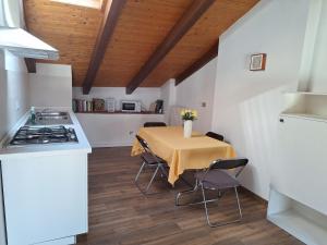 a kitchen with a table with chairs and a stove at AL30 Studios in Viverone