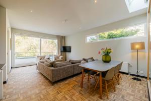 a living room with a couch and a table at Bloemendaal Hotel Collection Apartments in Bloemendaal