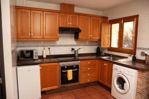 a kitchen with wooden cabinets and a sink and a dishwasher at Castle House Xativa in Xàtiva