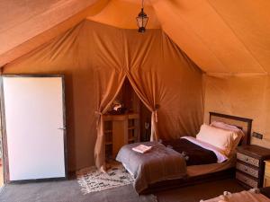 a bedroom with a bed in a tent at Isma Luxury Camp in Merzouga +83 photos