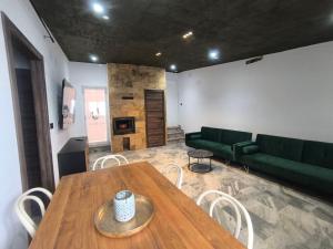 a living room with a table and a green couch at La BUHARDILLA DE CHARLIN in Casas de Ves