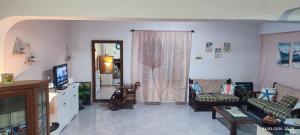 a living room with a couch and a tv at ToMa House in Pellaro