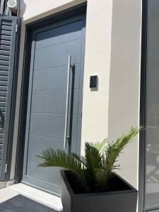 a garage door with a plant in front of it at Blue Breeze in Paralia Vrachou