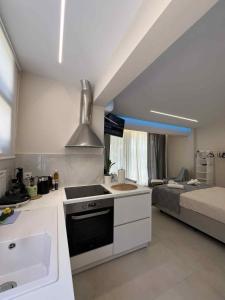 a kitchen with a stove and a sink and a bed at Blue Breeze in Paralia Vrachou
