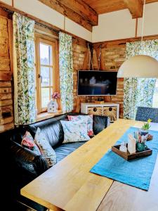 a living room with a wooden table and a couch at Liljas Haus im Spreewald in Burg