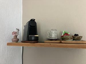 a wooden shelf with a coffee maker and other items on it at B&B My Suite Home in Bruges