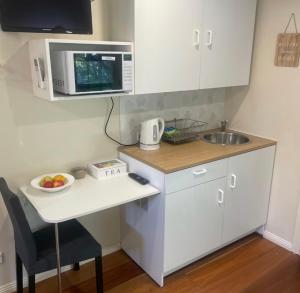 a small kitchen with a table and a microwave at Dees Front Studio Room in Hazelbrook