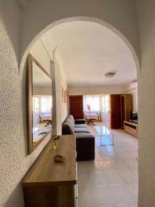 a living room with a couch and a mirror at Apartament La Mata in La Mata