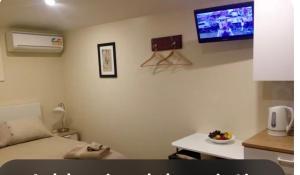 a room with a bed and a tv on the wall at Dees Front Studio Room in Hazelbrook