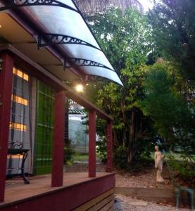 a house with a large umbrella on a porch at Dees Front Studio Room in Hazelbrook