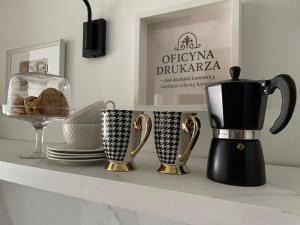 a counter with two coffee mugs and a blender at Oficyna Drukarza in Wschowa +3 photos