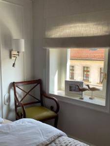 a bedroom with a bed and a chair and a window at Oficyna Drukarza in Wschowa
