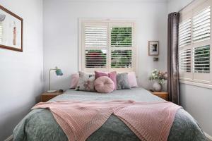a bedroom with a large bed with pink pillows at Coorabin in Orange