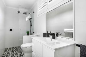 a white bathroom with a sink and a toilet at Coorabin in Orange
