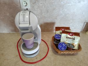 a coffee maker with a cup and a basket of food at Апартамент Ивела in Balchik