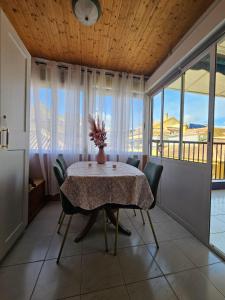 a dining room with a table and chairs and windows at Apartament La Mata in La Mata